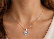 Close-up of a round pendant on a delicate gold-colored necklace